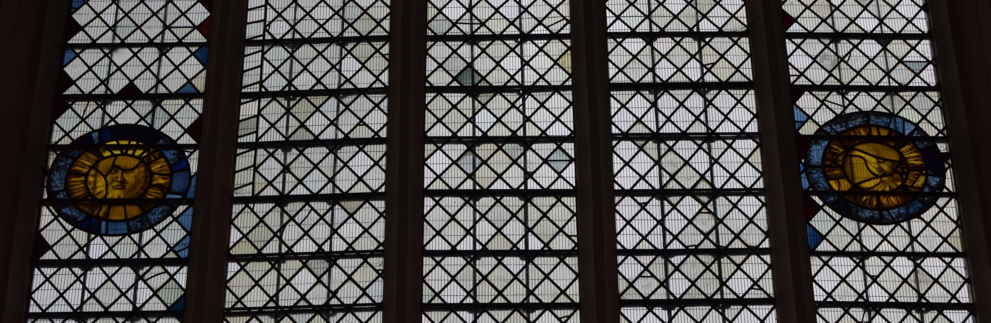 Stained glass windows of the sun and moon, Clare, Suffolk.