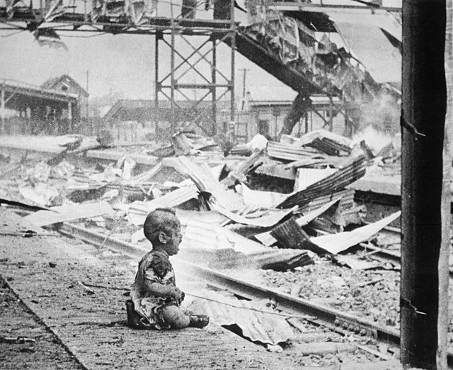 Bloody Saturday, Shanghai, 1937. This terrified baby was one of the only human beings left alive in Shanghai's South Station after its bombing by the Japanese. Photograph by Chinese photojournalist H. S. Wong.
